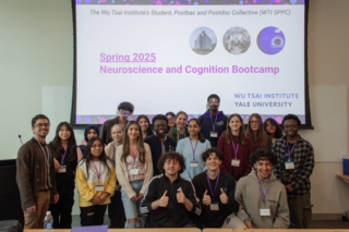 Group photo of smiling individuals in front of a screen displaying "Spring 2025 Neuroscience and Cognition Bootcamp" at Wu Tsai Institute.