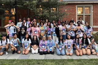 Summer Scholars pose in their tie-dye Pathways t-shirts inside of Benjamin Franklin residential college.